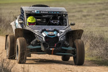 Madrid, İspanya; 02-15-2025: Can-Am Maverick X3 at arabası toprak yolda hızlanıyor, çevik manevraları ve toz izleri off-road yarışlarının maceracı ruhunu vurguluyor
