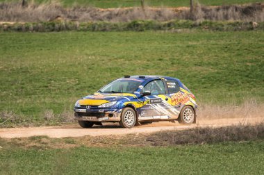 Madrid, İspanya; 02-15-2025: Eski Peugeot 206 ralli arabası toprak ve çakıl pistinde toz kaldırıyor