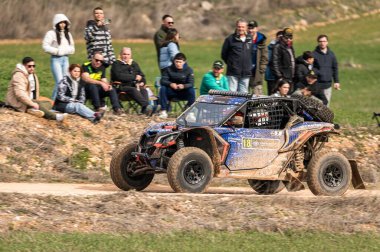 Madrid, İspanya; 02-15-2025: Can-Am Maverick X3 at arabası toprak yolda hızlanıyor, çevik manevraları ve toz izleri off-road yarışlarının maceracı ruhunu vurguluyor
