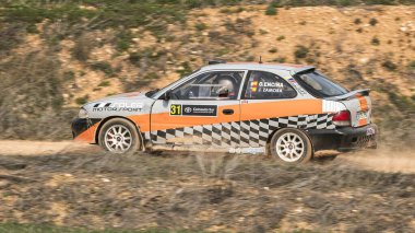 Madrid, İspanya; 02-15-2025: Toprak ralli yarışında Hyundai Accent Coupe 'nin güçleri hız ve hassasiyetle virajları zorluyor. Motor sporunda dinamik bir an