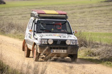 Madrid, İspanya; 02-15-2025: Modifiye edilmiş bir Fiat Panda 4x4, toprak bir yolda bir ralli safhasında kırsal alanda toz kaldırarak yarışır. Dinamik bir off-road çekimi