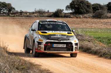 Madrid, İspanya; 02-15-2025: Toyota GR Yaris yarış arabası tozlu bir pistte, saldırgan duruşu ve hızı heyecan verici bir motor sporu anı yaratıyor. En iyi şekilde toplanıyor.!