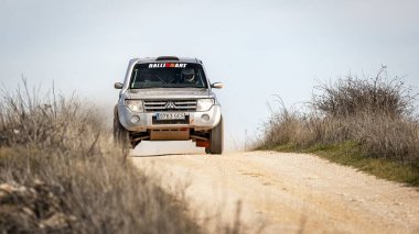 Madrid, İspanya; 02-15-2025: Gri Mitsubishi Montero bir off-road rali sahnesinde güç kazandı, engebeli araziyi hassasiyet ve dayanıklılıkla ele alırken tozu tekmeledi