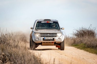 Madrid, İspanya; 02-15-2025: Gri Mitsubishi Montero bir off-road rali sahnesinde güç kazandı, engebeli araziyi hassasiyet ve dayanıklılıkla ele alırken tozu tekmeledi
