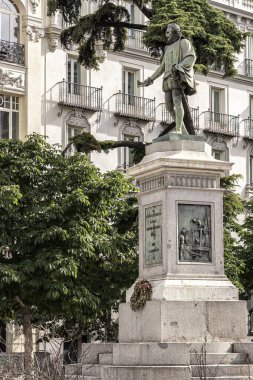 Madrid, İspanya; 06-20-2025: Plaza de las Cortes, Madrid, İspanya 'da Miguel de Cervantes heykeli. Tarihi mimari ve şehir cazibesiyle çevrili ikonik İspanyol yazara bir övgü.