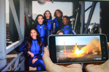 Jiangmen, Guangdong, Çin-15 Nisan 2025: İnsanlar Katy Perry 'nin uzaya başarıyla uçup Mavi Köken uzay aracıyla Dünya' ya dönüşünü izlemek için akıllı telefon kullanıyor..