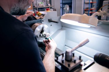 Bir torna tezgahında trombon ve öforyum ağızlık cilalayan müzik aleti tamircisi. 