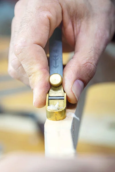 Atölyesinde Luthier Planing Vihuela boyun dikey çekim. Ellerini yaklaştır..