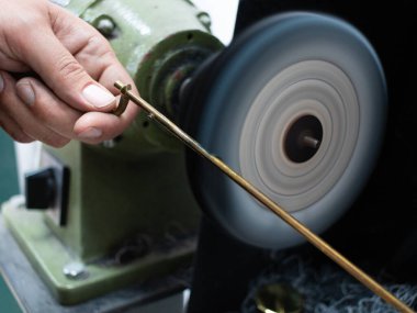 Bir saksafonun uzun anahtarını zımparalıyorum.