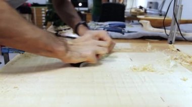 Marangoz bir lavtanın ahşap alt kapağını dikiyor.