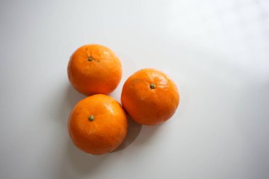 Beyaz arkaplanlı üç taze portakal
