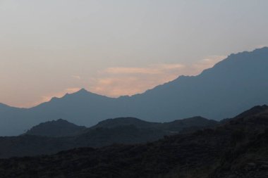 Bulutlu ve mavi gökyüzü olan dağ manzarası