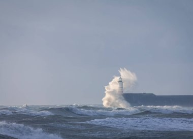 Newhaven deniz fenerinde rüzgarlı bir kış gününde dalgalar çarpar Seaford 'un doğusundaki doğu Sussex' ten batıya bakar