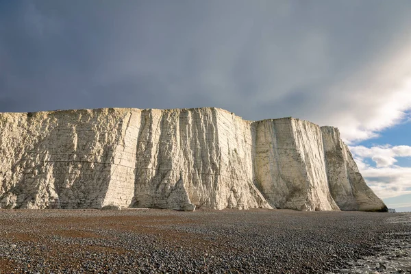 Dramatic chalk cliffs of the Seven Sisters rising above at low tide on the East Sussex coast, south east England UK