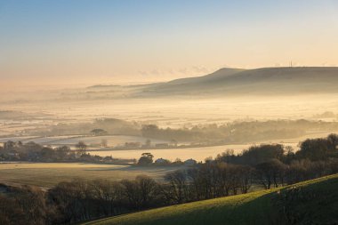Aralık ayının puslu sabahında Kingston Ridge 'den güneydoğuya, doğu Sussex güney İngiltere' ye Caburn Dağı 'na doğru gün doğuyor.