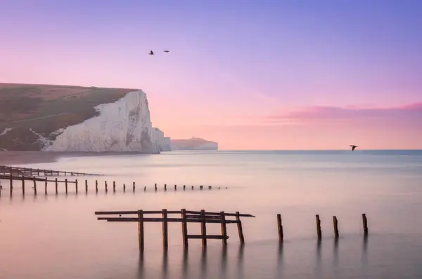 英国东南萨塞克斯海岸的库克米尔港和七姊妹悬崖的涨潮的淡紫色天空日出 — 图库照片