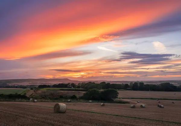 Dramatic August harvest afterglow sunset from Wilmington Hill on the south downs in east Sussex south east England UK