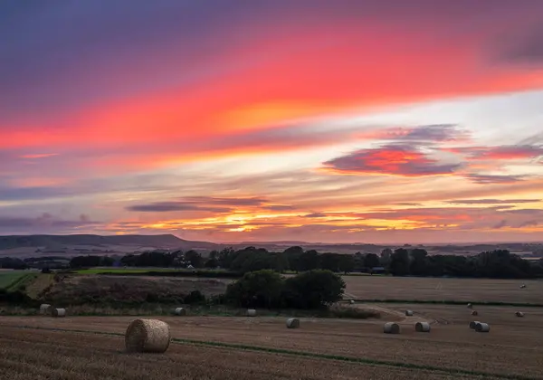 Dramatic August harvest afterglow sunset from Wilmington Hill on the south downs in east Sussex south east England UK
