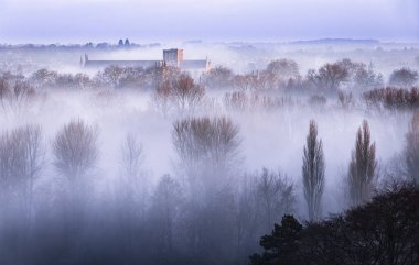 Şubat ayının erken saatlerinde Hampshire 'ın güneyindeki St. Catherine Tepesi' nde Winchester Katedrali 'nin şafak güneşini yakalamak için yükseldiği güney doğu İngiltere' de..  