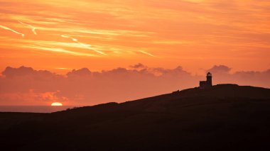 December sunrise behind Belle Tout lighthouse Birling Gap from Went Hill on the south downs east Sussex south east England UK clipart