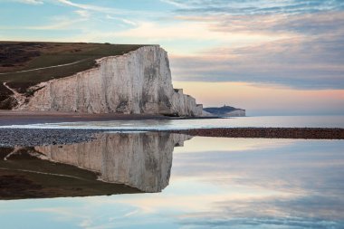 Yedi Kız Kardeş Cuckmere Brow, İngiltere 'nin güneydoğusundaki Sussex sahilindeki Cuckmere Haven' da günbatımında sakin bir gelgit havuzuna yansıdı.