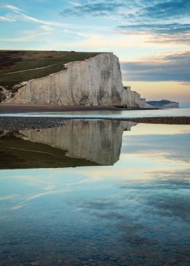 Yedi Kız Kardeş Cuckmere Brow, İngiltere 'nin güneydoğusundaki Sussex sahilindeki Cuckmere Haven' da günbatımında sakin bir gelgit havuzuna yansıdı.