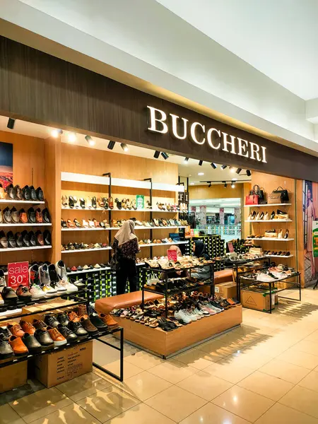 Surabaya - Endonezya, 21 Mart 2024. Çekici bir ayakkabı mağazası düzeni, modern tasarımın dokunuşuyla sergilenen vitrinler, doğru ışıklandırma ziyaretçileri cezbedecek. Yan görünüm göz seviyesi.