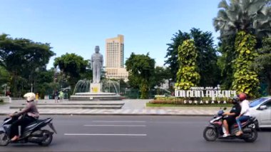 Surabaya, 28 Nisan 2024 Apsari Parkı ve sömürgecilere karşı savaşan bir vali olan Vali Surjo 'nun heykeli. Surabaya şehir merkezinde yer alıyor. Genellikle halk tarafından egzersiz için kullanılır. Caddenin karşısından görüldü.