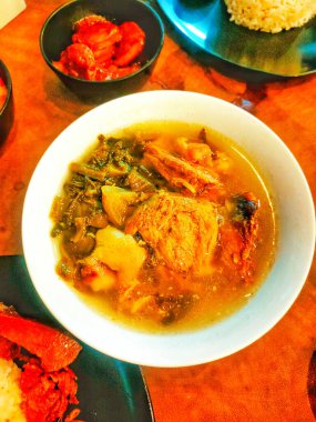 Baikut tuzlu sebzeler, tuzlu sebzeler domuz etli çorba olarak pişiriliyor. Çin usulü pişirilmiş, ahşap bir masada servis edilmiş. Yüksek Açı Seviyesi.