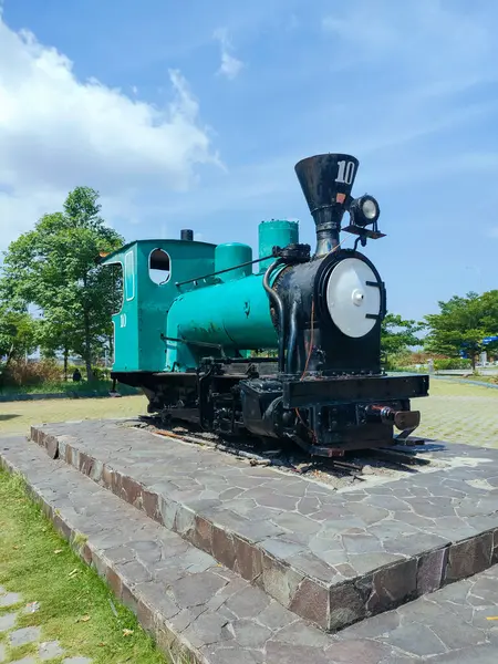 stock image Brebes - Indonesia, July 3, 2024.Monument to a locomotive pulling a lorry carrying sugarcane, in a former sugar factory that now functions as a rest area. 