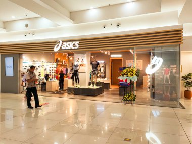 Tangerang, Endonezya, 5 Temmuz 2024.Asics ayakkabılarının ve spor giyim mağazasının modern şık tasarımlı, sportif, rahat ve ziyaretçilere hitap eden ön manzarası. Göz düzeyi görünümü.