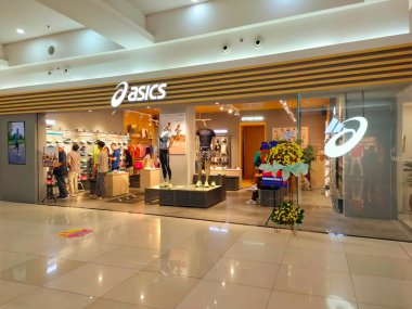 Tangerang, Endonezya, 5 Temmuz 2024.Asics ayakkabılarının ve spor giyim mağazasının modern şık tasarımlı, sportif, rahat ve ziyaretçilere hitap eden ön manzarası. Göz düzeyi görünümü.