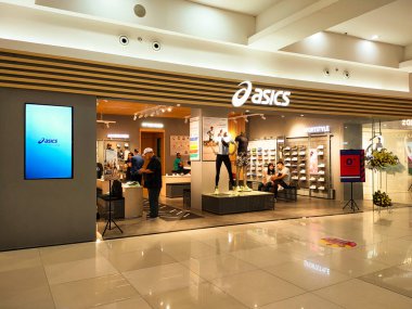 Tangerang, Endonezya, 5 Temmuz 2024.Asics ayakkabılarının ve spor giyim mağazasının modern şık tasarımlı, sportif, rahat ve ziyaretçilere hitap eden ön manzarası. Göz düzeyi görünümü.
