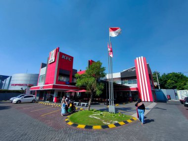 Surabaya - Endonezya, 26 Temmuz 2024 Kırmızı ve Beyaz bayrak, Endonezya 'nın Bağımsızlık Günü kutlamalarında bir fast food restoranının önünde gururla dalgalanıyor. Balık bakışı.