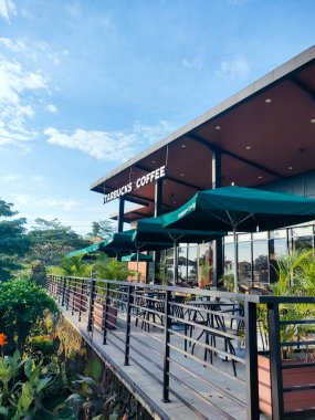 Ungaran - Endonezya, 7 Temmuz 2024 Starbucks açık hava terasında dinlenme alanı KM 429 A 'da paralı yol kullanıcıları için bir tesis olarak Trans Java otoyolu üzerindeki çevreye karışan masa alanı.