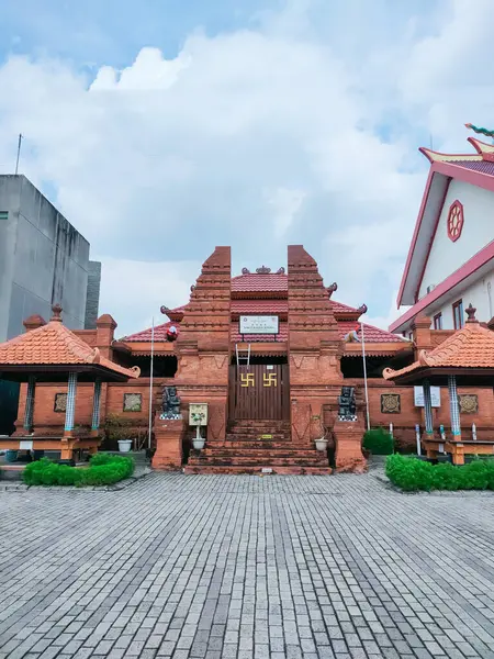 stock image Surabaya - Indonesia, April 18, 2024.Front view of Pura Sakti Raden Wijaya at Royal Residence, with red brick and distinctive gate. In the morning eye view level.