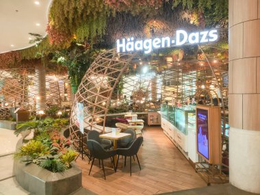 Surabaya - Endonezya, 27 Eylül 2024 Haagen-dazs restoranının masaları, sandalyeleri, bitkileri ve eşsiz, sanatsal ahşap tasarımı. Alışveriş merkezinin içinde..