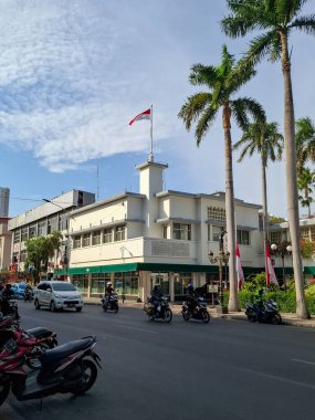 Surabaya - Indonesia, September 30, 2024.Left side view of Majapahit Hotel, formerly Orange Hotel, the location of the tearing of the Red and White Blue Dutch flag into Red and White Indonesian flag. clipart