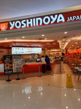 Surabaya - Indonesia, October 9, 2024.Front view of Restaurant Yoshinoya with Japanese atmosphere, light and attractive wooden elements. Eye level view. clipart