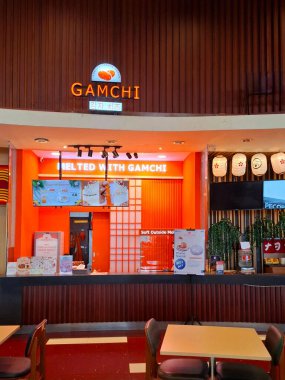 Surabaya - Endonezya, 8 Ekim 2024 Gamchi standının Kore peynirli ekmeği servis edişi. Modern ahşap dizaynla, Surabaya 'da bir alışveriş merkezinin içinde şık görünüyor. Göz görünümü düzeyi.