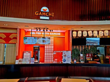 Surabaya - Endonezya, 8 Ekim 2024 Gamchi standının Kore peynirli ekmeği servis edişi. Modern ahşap dizaynla, Surabaya 'da bir alışveriş merkezinin içinde şık görünüyor. Göz görünümü düzeyi.