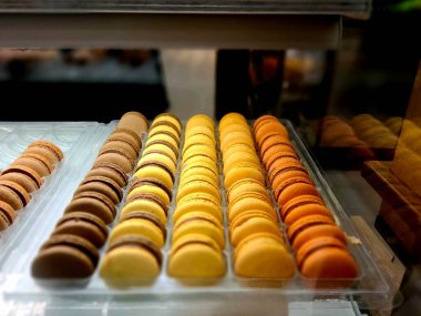 Cam bir vitrinde sıralanmış çeşitli renklerde makarna alıcılar için çok çekici görünür..