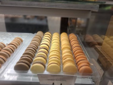 Cam bir vitrinde sıralanmış çeşitli renklerde makarna alıcılar için çok çekici görünür..