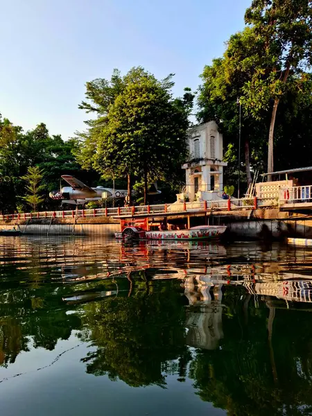 Surabaya, Endonezya, 27 Ekim 2024 Surabaya Denizaltı Anıtı turistik tekne iskelesi, arka planda ağaçlarla Kalimas nehri boyunca uzanır. Şehir turu tesisi, öğleden sonra..
