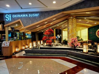 Jakarta - Endonezya, 11 Mart 2025. Bir alışveriş merkezindeki OKINAWA SUSHI Japon restoranının ön görüntüsü. Japon nüanslarını davet eden dinamik bir tasarıma sahip, sıcak, modern, zarif, lüks. Göz düzeyi görünümü.