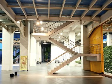 Surabaya - Endonezya, 24 Mart 2025. Üst katlara giriş için çelik merdiven yapısı ve estetik iç mekan. Geceleri, göz hizasında..