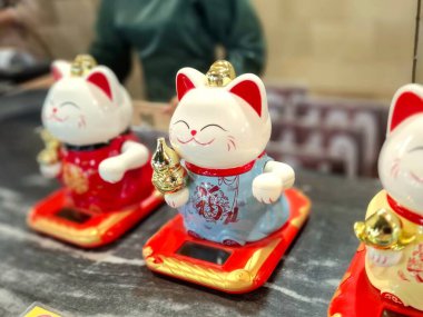 Magelang - Endonezya, 31 Mart 2025. Tatlı Şanslı Kedi, kasiyerin önüne serildi. Servet getirmesi için sevimli bir süs ve inanç olarak..