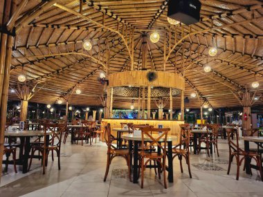 Sidoarjo - Endonezya, 19 Nisan 2025. Endonezya 'da geleneksel modern Endonezya konseptiyle, sanatsal bambu malzemeleriyle dolu bir yemek alanı. Gece dingin aydınlatmayla.