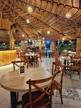 Sidoarjo - Endonezya, 19 Nisan 2025. Endonezya 'da geleneksel modern Endonezya konseptiyle, sanatsal bambu malzemeleriyle dolu bir yemek alanı. Gece dingin aydınlatmayla.