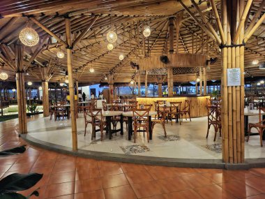 Sidoarjo - Endonezya, 19 Nisan 2025. Modern Endonezya geleneksel konseptine sahip bambu yapı yemek alanı. Gece dingin aydınlatmayla.